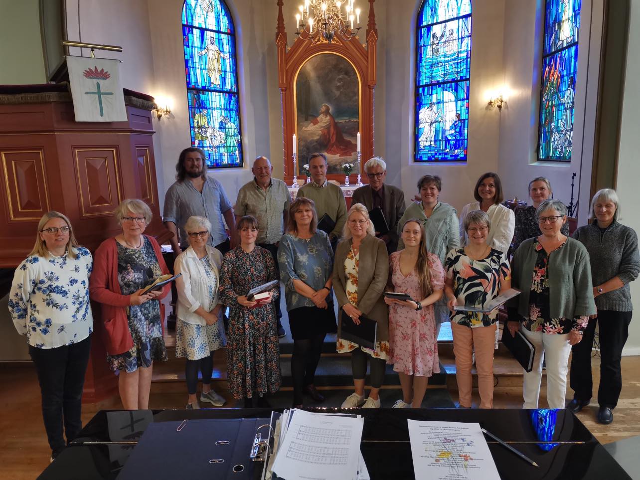 Medlemmer i Årnes kirkekor oppstilt på to rader foran i koret i Årnes kirke