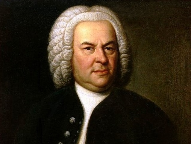 Johann Sebastian Bach i mørk jakke mot mørk bakgrunn.