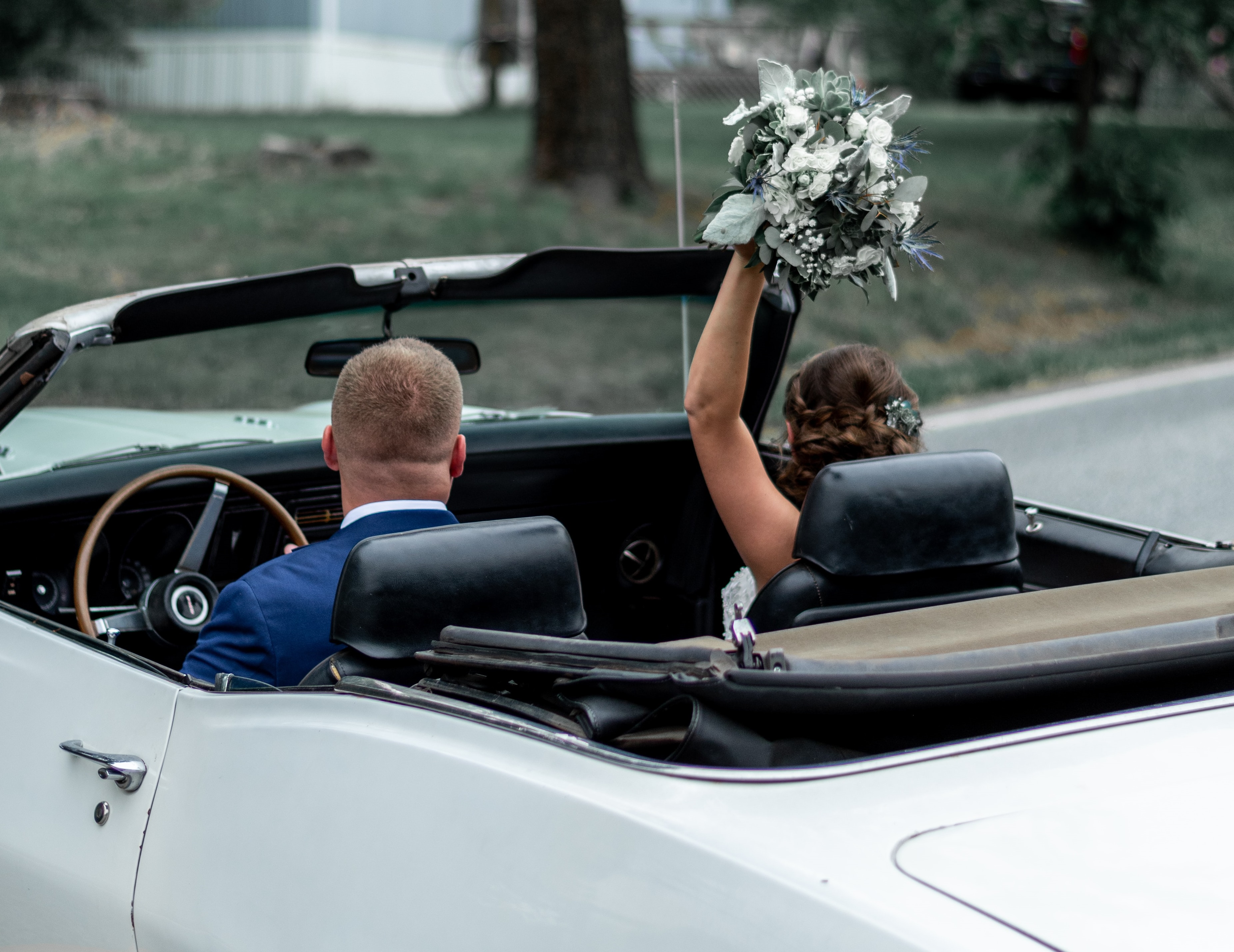 Brudefolk som kjører av gårde i bil etter å ha blitt gift